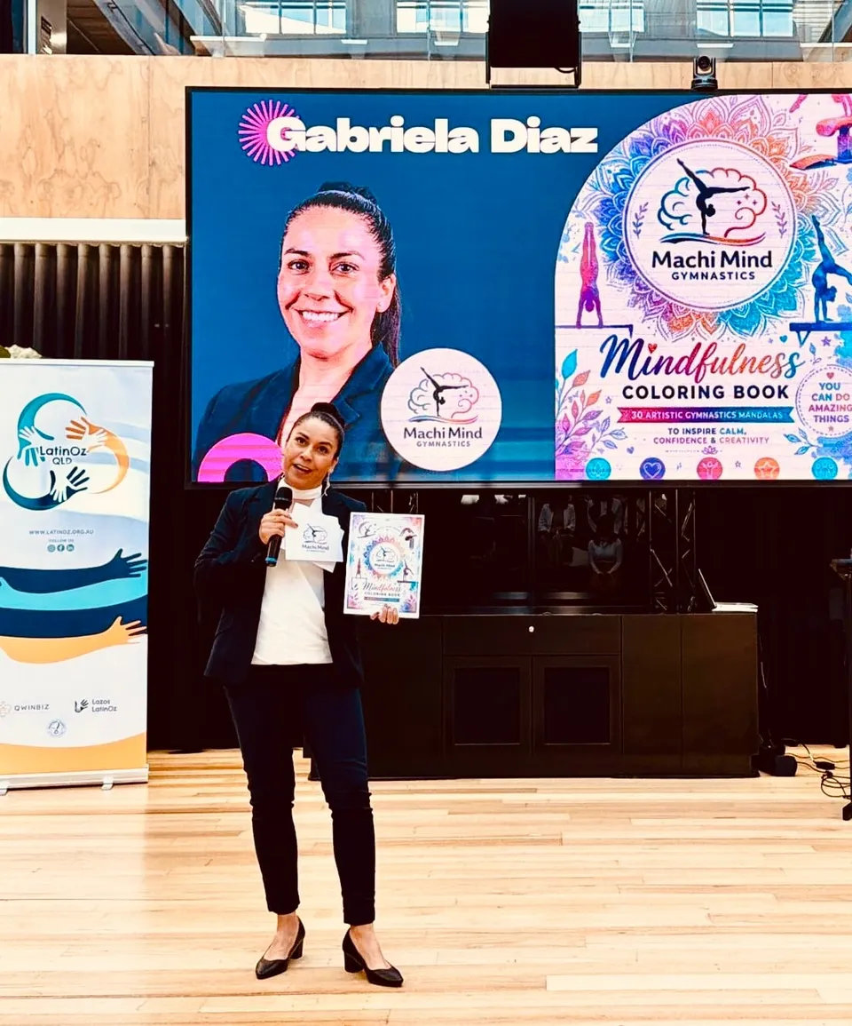 Gabriela presenting the Mindfulness Colouring Book on stage at a community event
